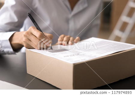Cropped closeup shot unknown businesswoman labeling or signing package box 117974893