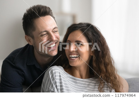 Happy couple laughing spend carefree time together at home, closeup Happy couple laughing spend carefree time together at home, closeup 117974964