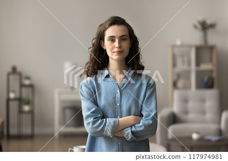 Serious woman standing in modern living room Serious woman standing in modern living room 117974981