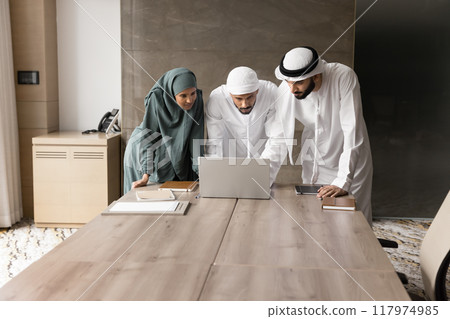 Arabian business colleagues in Muslim clothes using laptop together 117974985