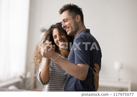 Overjoyed couple in love dancing at home Overjoyed couple in love dancing at home 117975077