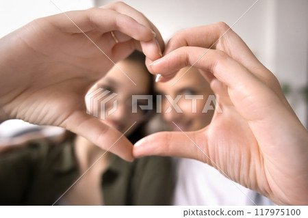 Mother and adolescent girl showing love sign Mother and adolescent girl showing love sign 117975100