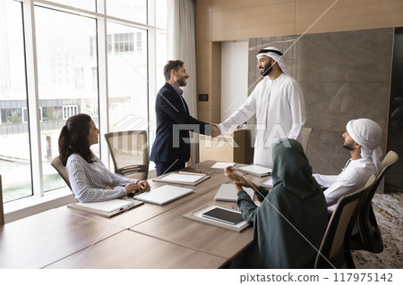 Positive confident Arab and European businessmen shaking hands 117975142