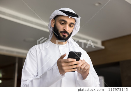 Serious young Arabic company leader using wireless Internet communication 117975145
