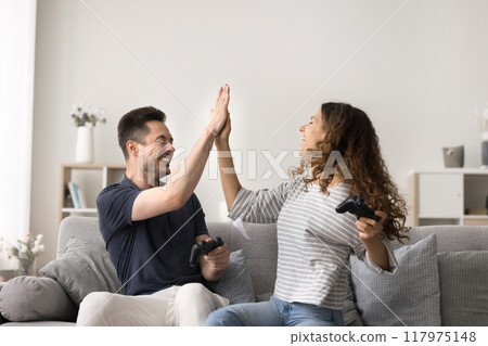 Cheerful Hispanic couple celebrate victory at console game 117975148