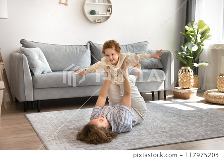 Mother play with little son lifts his in outstretched arms 117975203