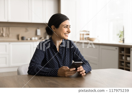 Cheerful young woman spend time at home use smartphone 117975239