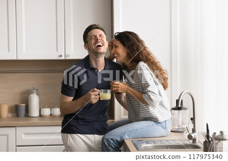 Happy couple spend time together drinking juice, talking and laughing Happy couple spend time together drinking juice, talking and laughing 117975340