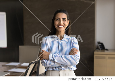 Happy beautiful young Hispanic businesswoman posing in office meeting room Happy beautiful young Hispanic businesswoman posing in office meeting room 117975347