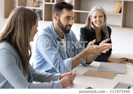 Positive handsome Hispanic professional man talking to diverse group Positive handsome Hispanic professional man talking to diverse group 117975440