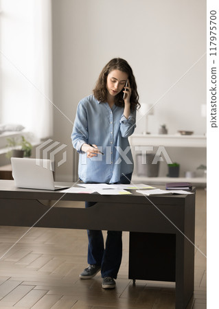 Female talking on smartphone discussing important work matters to colleague Female talking on smartphone discussing important work matters to colleague 117975700