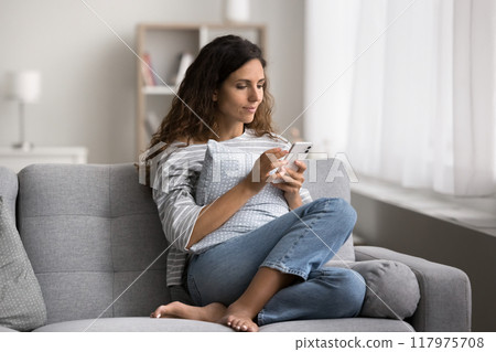 Hispanic woman using modern smartphone spend free time on internet Hispanic woman using modern smartphone spend free time on internet 117975708