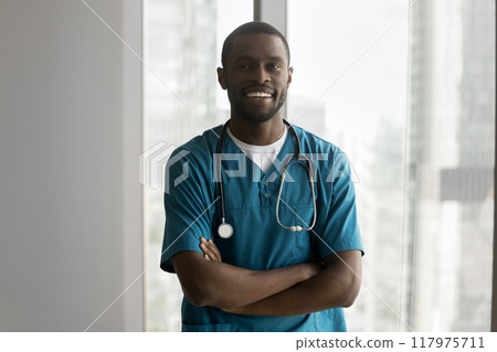 African man doctor in blue medical scrubs stand in office African man doctor in blue medical scrubs stand in office 117975711