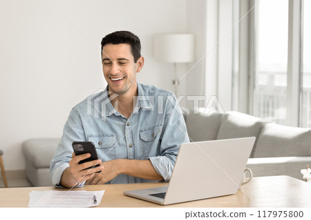 Happy successful Latin freelance businessman using digital gadgets Happy successful Latin freelance businessman using digital gadgets 117975800