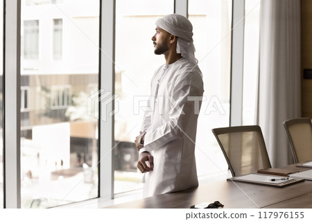 Pensive Arab executive man looking out of window Pensive Arab executive man looking out of window 117976155