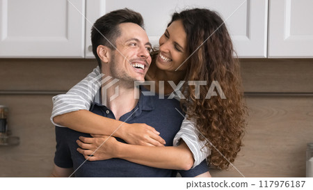 Loving Hispanic spouses spend time together in renovated modern kitchen 117976187