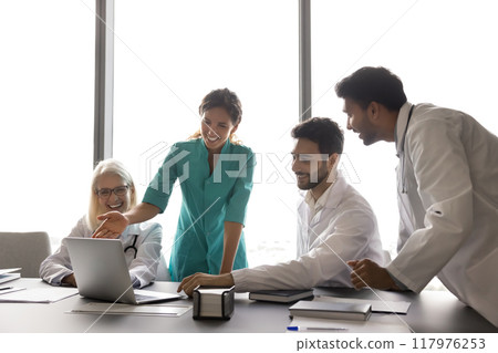 Multiethnic laughing internists using laptop in conference room Multiethnic laughing internists using laptop in conference room 117976253