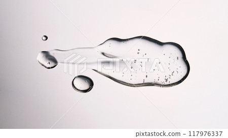 A smear of cosmetic gel close-up on a gray background. Appetizing texture with bubbles. A smear of cosmetic gel close-up on a gray background. Appetizing texture with bubbles. 117976337
