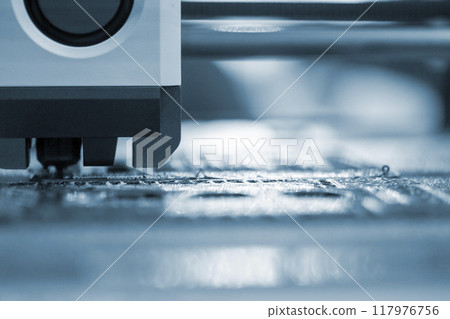 3D printer close up. A working 3D printer in process of printing object from molten plastic. 3D printer creating model by flowing liquid plastic from an extruder of printer. 3D printing technology 117976756