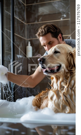 The luxurious setting enhances the experience as the man attends to his pet, ensuring cleanliness and comfort during the bath, reflecting a harmonious bond between owner and furry companion 117976769