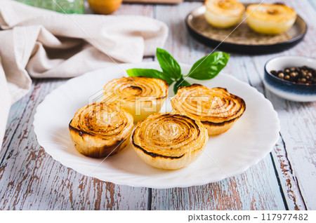 Caramelized roasted onions and basil on a plate on the table 117977482