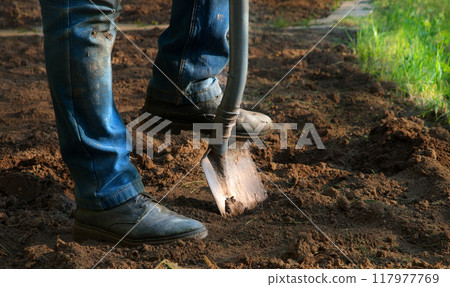 Man's feet with a shovel 117977769