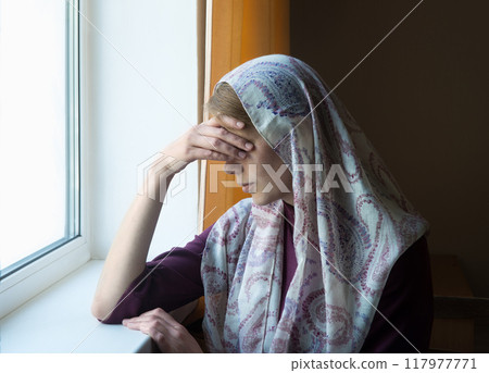Woman thinking at the window 117977771