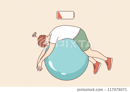 Tired man lies on fitness ball with empty battery, symbolizing exhaustion and lack of vitality 117978071