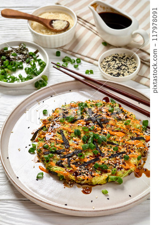 Japanese pancake with cabbage on a plate, top view 117978091
