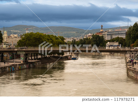 Vienna, Austria, August 23, 2022. Cityscape with the Danube and the chimney of the Spittelau waste-to-energy plant that attracts attention with its modern and colorful appearance. 117978271