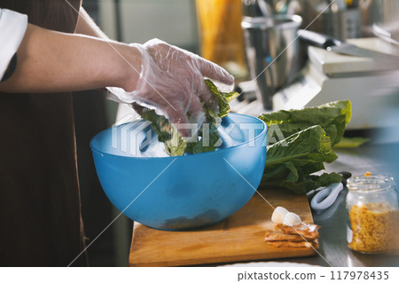 Male chef preparing salad in commercial kitchen Male chef preparing salad in commercial kitchen 117978435