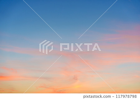 Breathtaking sunset sky showcasing vibrant pastel orange, pink, and blue colors over the horizon 117978798