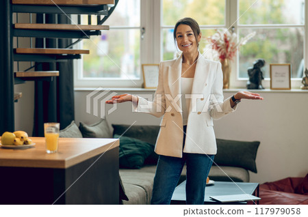 Woman in white jacket standing in the middle of the room and looking contented Woman in white jacket standing in the middle of the room and looking contented 117979058