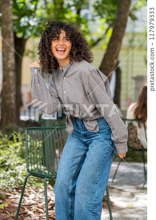 Young woman shouting celebrating success winning goal achievement good victory news on city street Young woman shouting celebrating success winning goal achievement good victory news on city street 117979333