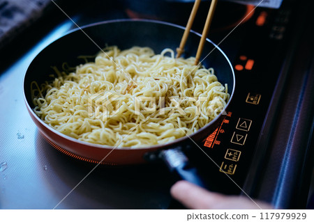 A woman's hands frying yakisoba noodles A woman's hands frying yakisoba noodles 117979929