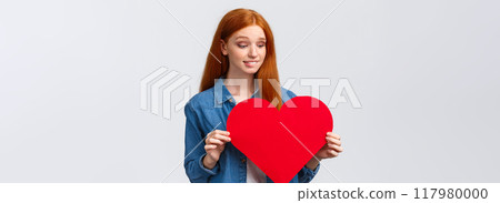 Indecisive cute and timid, shy redhead girl wants confess in love, show sympathy unsure give present on valentines day or not, holding big red heart, biting lip worried, white background 117980000