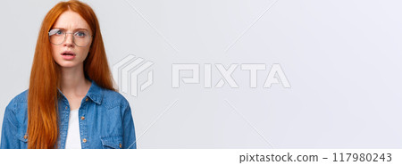 Confused and displeased, unsure redhead girl in glasses having conversation, talking look frustrated and slightly unconvinced, have doubts standing white background frowning 117980243