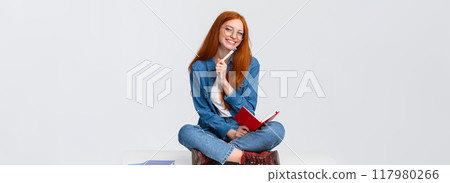 Charismatic, friendly cute redhead girl dreaming, taking notes or prepare homework while sitting on floor with legs crossed, holding notebook and pen, writing over white background Charismatic, friendly cute redhead girl dreaming, taking notes or prepare homework while sitting on floor with legs crossed, holding notebook and pen, writing over white background 117980266