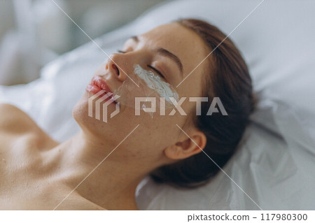 A professional beautician injects Botox into the face of a young woman A professional beautician injects Botox into the face of a young woman 117980300