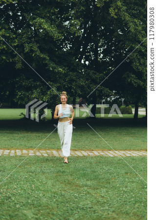 young woman athlete in sportswear practices yoga, enjoys training young woman athlete in sportswear practices yoga, enjoys training 117980308