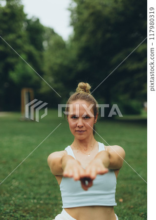 young woman athlete in sportswear practices yoga, enjoys training young woman athlete in sportswear practices yoga, enjoys training 117980319
