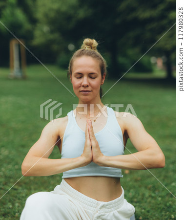 young woman athlete in sportswear practices yoga, enjoys training 117980328