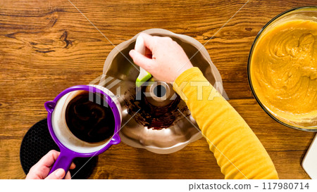 Flat lay. Carefully greasing a bundt cake pan in preparation for baking a delicious gingerbread bundt cake with caramel frosting. 117980714
