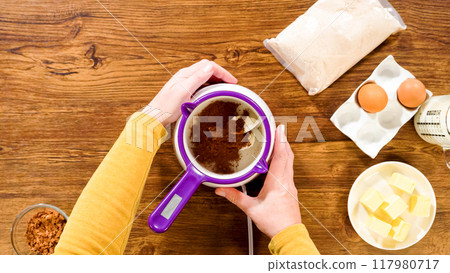 Flat lay. Carefully greasing a bundt cake pan in preparation for baking a delicious gingerbread bundt cake with caramel frosting. 117980717