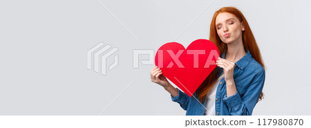 Romantic dreamy cute redhead teenager dreaming about giving boyfriend big red heart card to show her affection and love, celebrating valentines day with loved partner, standing white background Romantic dreamy cute redhead teenager dreaming about giving boyfriend big red heart card to show her affection and love, celebrating valentines day with loved partner, standing white background 117980870