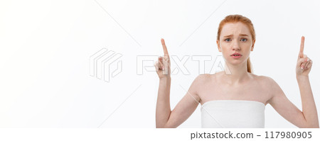 Portrait of caucasian cute in concern and shock, pointing index finger aside, over white background. Portrait of caucasian cute in concern and shock, pointing index finger aside, over white background. 117980905