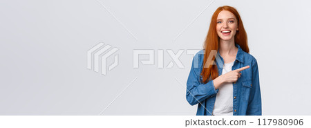 Carefree, friendly and happy outgoing redhead woman in denim shirt, pointing finger right and laughing at camera with beaming smile, standing white background, having discussion, communicate team Carefree, friendly and happy outgoing redhead woman in denim shirt, pointing finger right and laughing at camera with beaming smile, standing white background, having discussion, communicate team 117980906