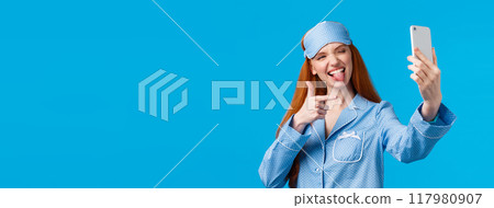 Sassy and popular redhead female blogger making live stream from bedroom talking about beauty and skincare routine, taking selfie on smartphone, show tongue and finger pistol Sassy and popular redhead female blogger making live stream from bedroom talking about beauty and skincare routine, taking selfie on smartphone, show tongue and finger pistol 117980907