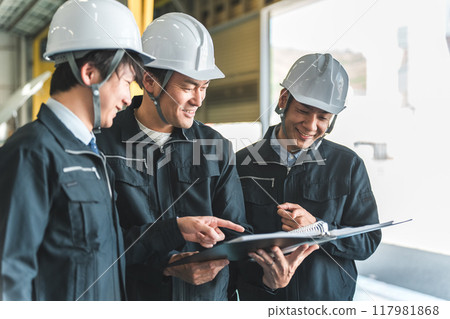 Male worker having a meeting at a factory, warehouse, or logistics center (process management) 117981868
