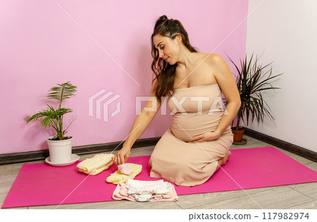 The intimate maternity moment unfolds on a vibrant pink mat 117982974